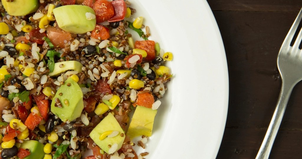 A colorful whole-grain salad with rice, corn, avocado and tomato